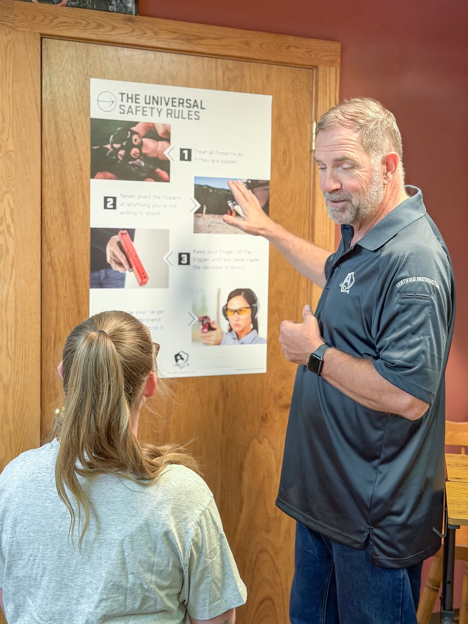 Michael Cannon explaining the universal firearm safety rules to a student