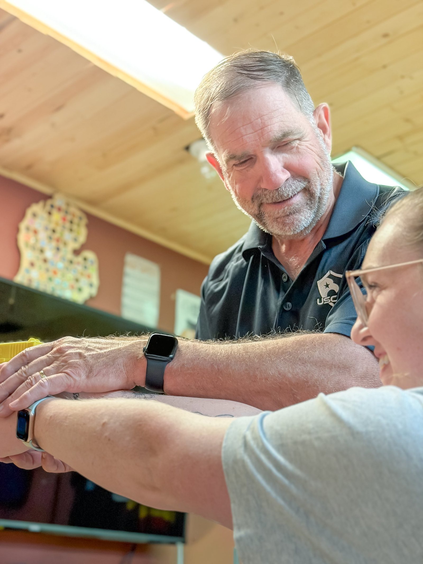 Michael Cannon smiling as he works closely with a student in the classroom